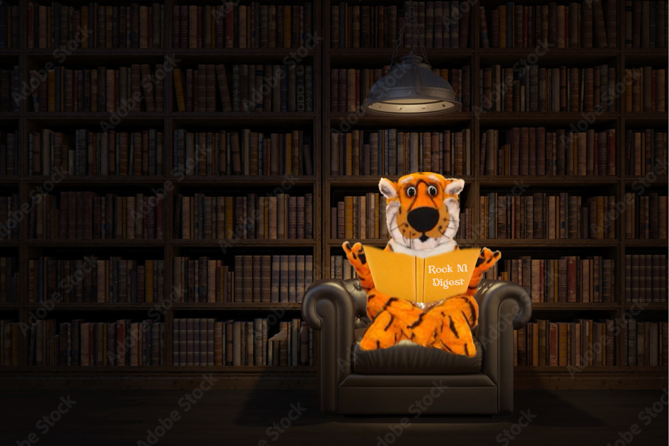 Truman the Tiger sitting under a lamp in a book-lined room, reading a book called “Rock M Digest”